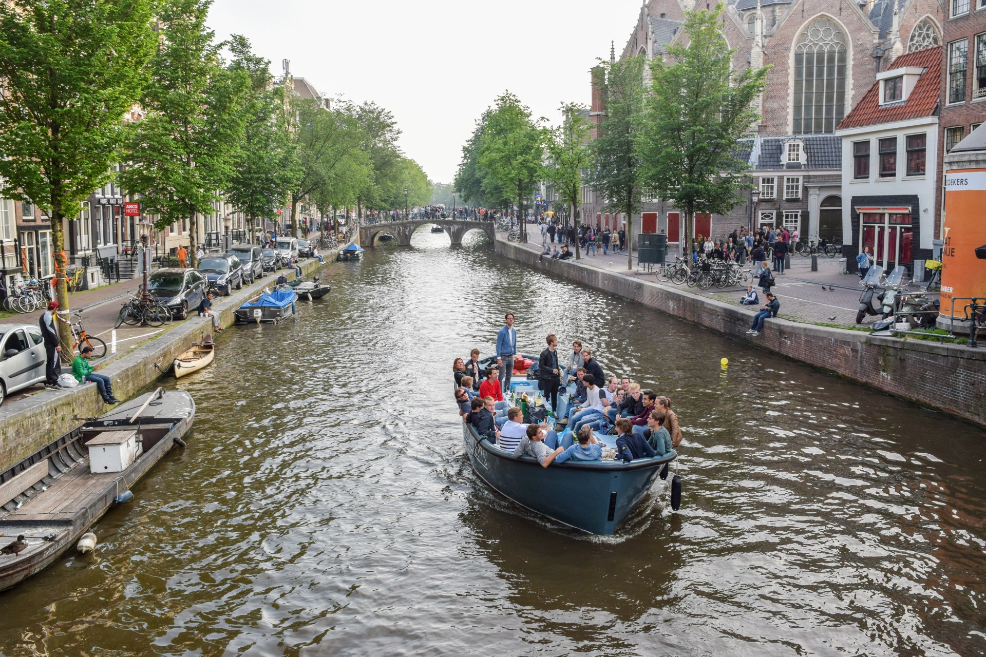Amsterdam’da bir kanalda teknede gezen gençler